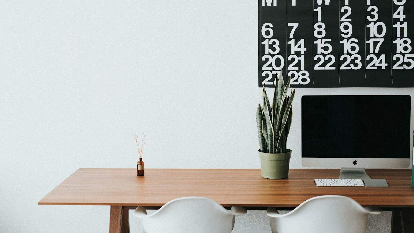 silver iMac on brown wooden desk